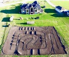 an aerial view of a home with a track in the yard