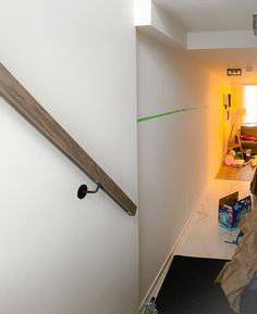 a woman is walking down the hallway in her house with bags on the floor next to her