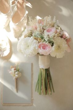 a bouquet of flowers sitting on top of a table next to a pair of shoes