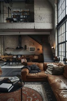 a living room filled with lots of furniture next to tall windows and a spiral staircase