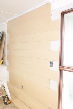 a room that has been painted white and is being worked on by a person with a paint roller