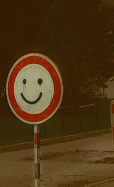 a red and white sign with a smiley face on it