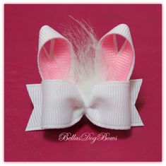 a pink and white bow with feathers on it