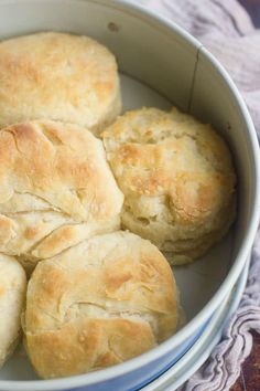 a white bowl filled with biscuits on top of a table