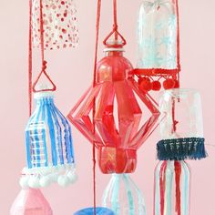 colorful glass ornaments hanging from strings on a pink background with red, white and blue decorations