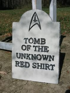 a sign that says, tomb of the unknown red shirt is in front of a white picket fence