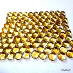 some very pretty gold colored beads on a white surface