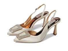 a pair of white high heel shoes with crystal buckles