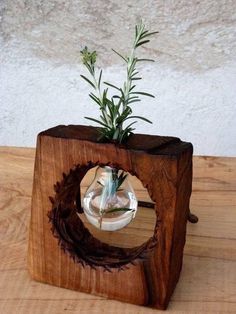 a small planter made out of wood with a glass vase on it's side