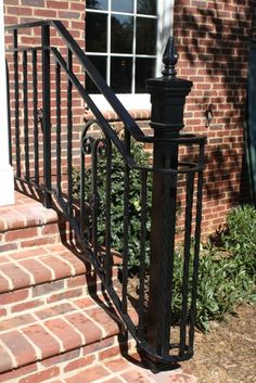 a wrought iron stair rail on brick steps