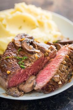 a piece of steak and mashed potatoes on a plate