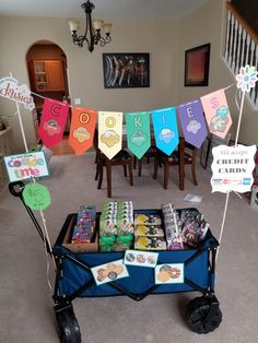 a cart filled with lots of candy sitting on top of a carpeted floor next to a table