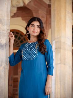 A charming blue and rayon kurta, meticulously adorned with yoke design & Chikankari detailing. The straight shape enhances its elegant silhouette, making it a perfect blend of traditional craftsmanship and contemporary style. Single Piece Fabric: Rayon Color: Blue Neck: Round Neck Sleeve: 3/4th Sleeves Style - Straight Shape with Regular Style Work Done: Yoke Design with Chikankari Detailing Length - Calf Length Washing Instructions: Hand Wash Size & Fit - Model's height is 5'8 wearing size smal Indigo Designer Straight Kurta, Designer Indigo Straight Kurta, Indigo Designer Wear Straight Kurta, Indigo Straight Kurta For Festive Occasions, Traditional Blue Top For Eid, Festive Straight Kurta Tunic With Zari Work, Chanderi Long Sleeve Kurta With Yoke, Festival Straight Kurta Top With Dabka Work, Blue Straight Kurta For Eid