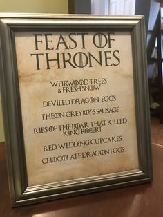 a framed game of thrones sign sitting on top of a table