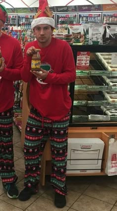 two men in matching christmas pajamas and santa hats