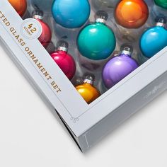 a box filled with colorful christmas ornaments on top of a table