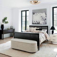 a bedroom with white walls and black furniture