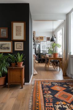 a living room filled with furniture and lots of plants on top of a wooden floor