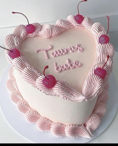 a heart shaped cake with pink frosting and cherries on top that says taurus babe