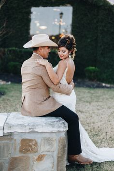 a bride and groom sitting on a stone bench