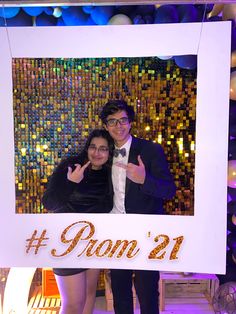 a man and woman posing for a photo in front of a sign that says pom'21