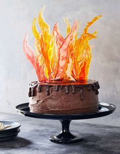 a chocolate cake with orange frosting and flames on top