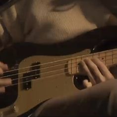 a person is playing an electric bass guitar