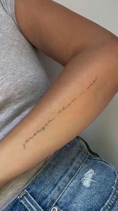 a woman with a tattoo on her arm and the word love is written in cursive writing