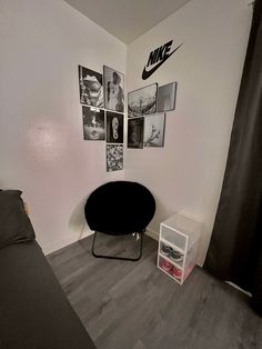 a bedroom with a black chair and pictures on the wall