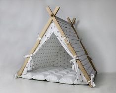 a teepee tent with white pillows on the floor