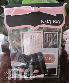 there is a small black and white camera in the package with pink ribbon on it