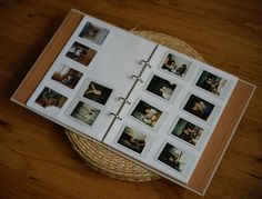 an open photo album sitting on top of a wooden table next to a wicker basket