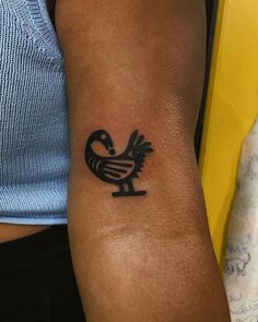 a small tattoo on the arm of a woman's left arm, depicting a bird