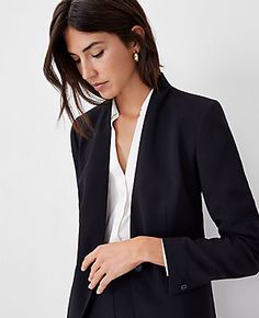 Elevate your wardrobe with the Ann Taylor Petite Long Collarless Blazer, a masterpiece of modern tailoring. This sleek, black blazer is designed to flatter with its collarless V-neck and tailored fit, ensuring a streamlined silhouette that hits perfectly at the hip.

- **Size:** Petite 8
- **Color:** Black
- **Material:** 95% Polyester, 5% Spandex
- **Gender:** Female
- **Length:** 25 1/2 inches long
- **Sleeves:** Long, button-open for styling versatility
- **Closure:** Single-button front
- ** Collarless Blazer, Long Sleeve Suit, Petite Blazer, Hip Style, Knitted Suit, Women's Blazers, Petite Jacket, Long Blazer, Womens Blazers