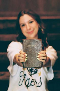 a woman holding up a book in front of her face