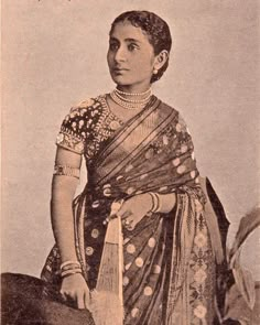 an old photo of a woman wearing a sari