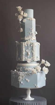 a blue wedding cake with white flowers on top