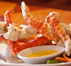 crab legs on a plate with dipping sauce