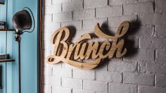 a wooden sign that says branch hanging on a brick wall next to a book shelf