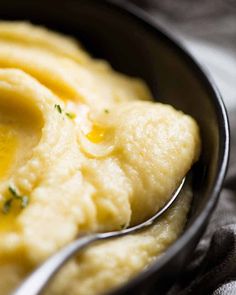 mashed potatoes in a black bowl with a spoon