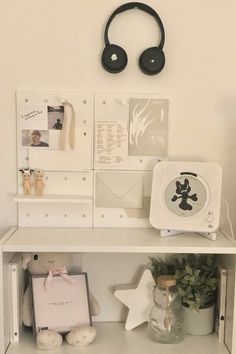 there is a shelf with various items on it and a clock above the top one