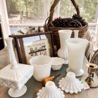 a table topped with white vases and pictures