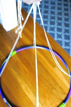 a person is holding a string attached to a circular object on a wooden table top