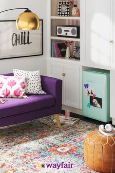 a living room with purple couches and colorful rugs on the floor in front of a white bookcase