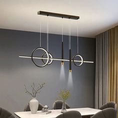 a dining room table with chairs and lights hanging from the ceiling