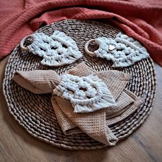 a woven piece of cloth on top of a wicker plate with two crocheted flowers