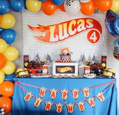 a blue table topped with cake and balloons