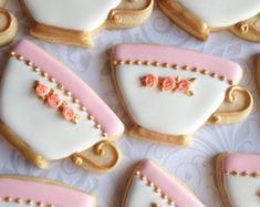 decorated cookies in the shape of purses with pink flowers on them are arranged together