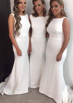 three women in white dresses standing next to each other