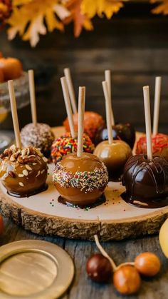 chocolate covered candies are arranged on a wooden platter with candy sticks sticking out of them